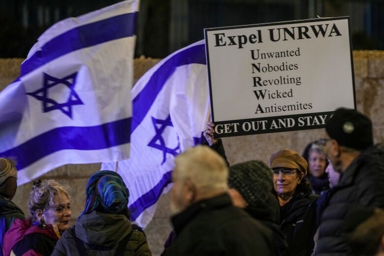 People waving Israeli flags take part in a protest.