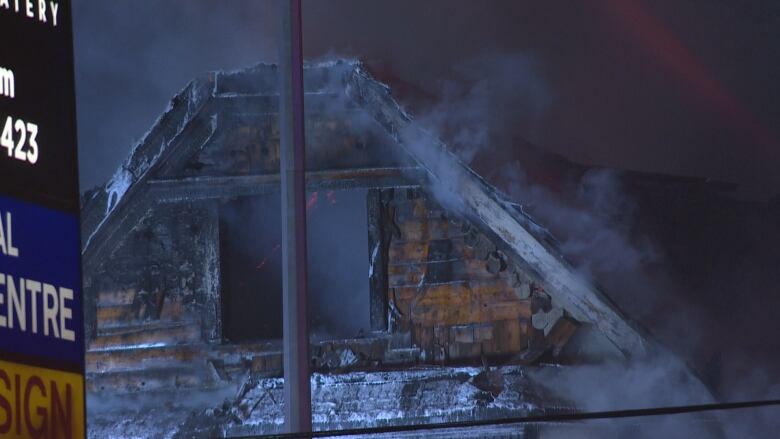 A burned-out window in an attic of a home.