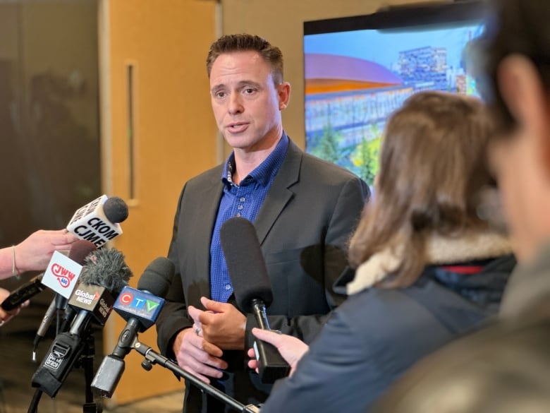 A man in a suit speaking into microphones.