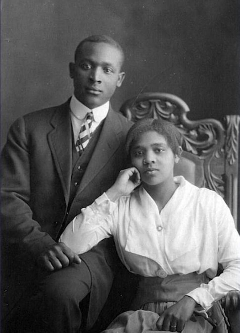 A man and woman pose in a black and white photograph 