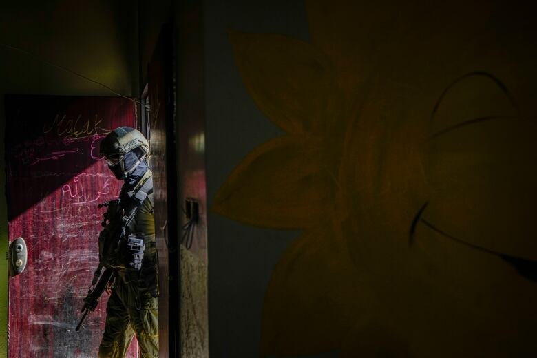 An Israeli soldier enters a building inside the UNRWA headquarters in Gaza City.