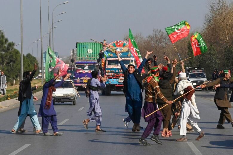 Men celebrate election results on the streets of Karachi, Pakistan.