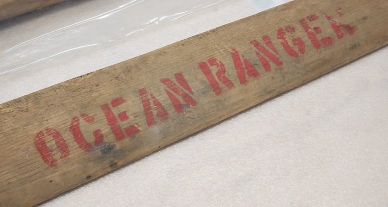 A plank of wood has the letters spelling out Ocean Ranger. 