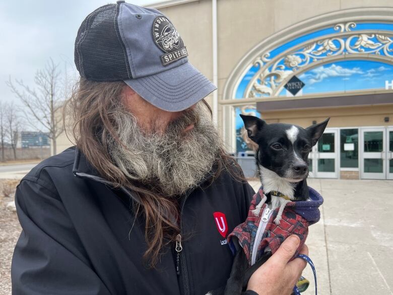 Man holds dog and looks at dog