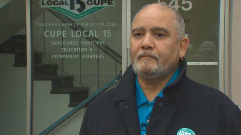 A man stands out front of a union office.