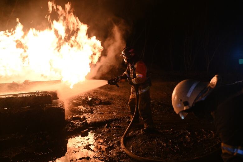 Ukrainian firefighters work to combat flames that ignited in wake of drone attack in Kharkiv on Feb. 10, 2024.