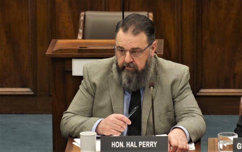 Hal Perry at desk with a name plate.