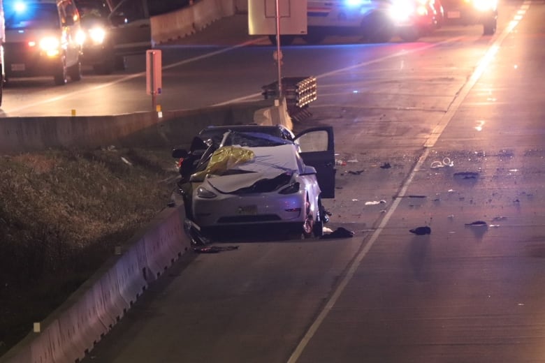 Two crashed vehicles on a highway shoulder are pictured with debris around them.