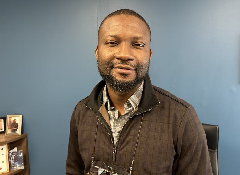 A Black man sits in an office.