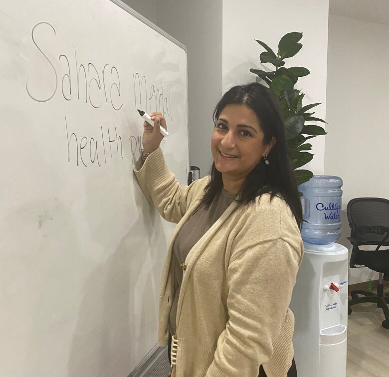 A woman writes on a whiteboard.