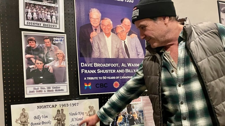 A person points to a piece of memorabilia on a wall covered in memorabilia. 