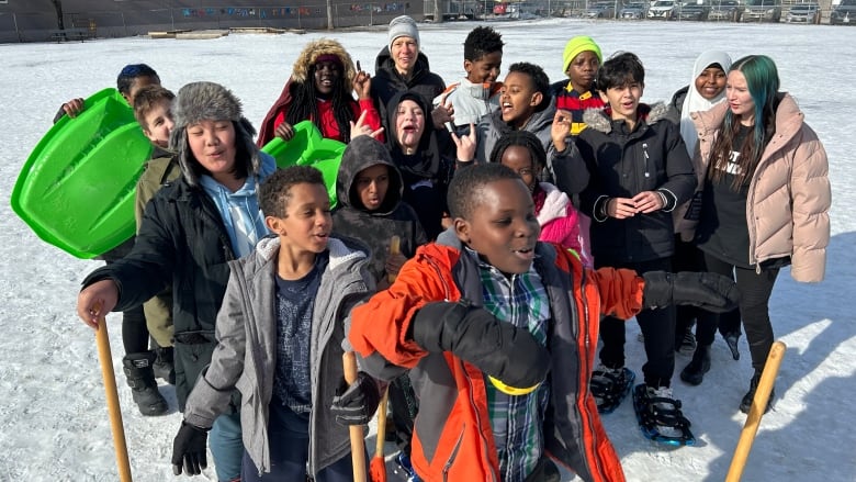 A group of people stand in a circle on a snowy field