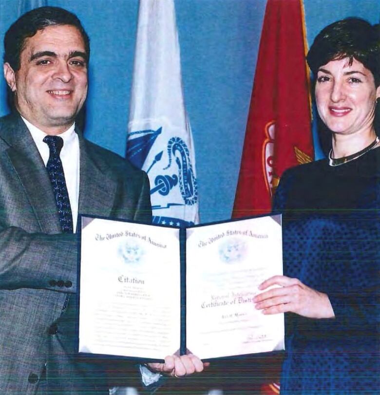 George Tenet, the former U.S. Director of Central Intelligence, is seen presenting a certificate to Ana Beln Montes.