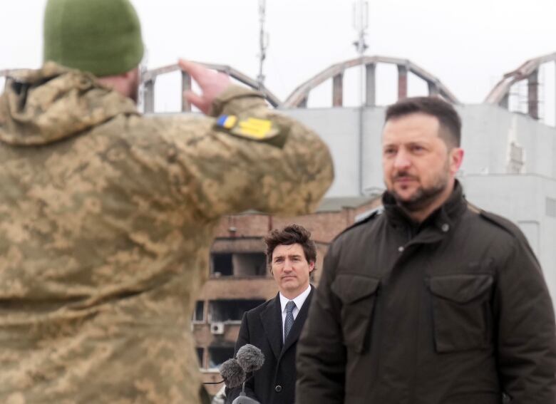 Soldier salutes Ukrainian President Volodymyr Zelenskyy and Canadian Prime Minister Justin Trudeau.