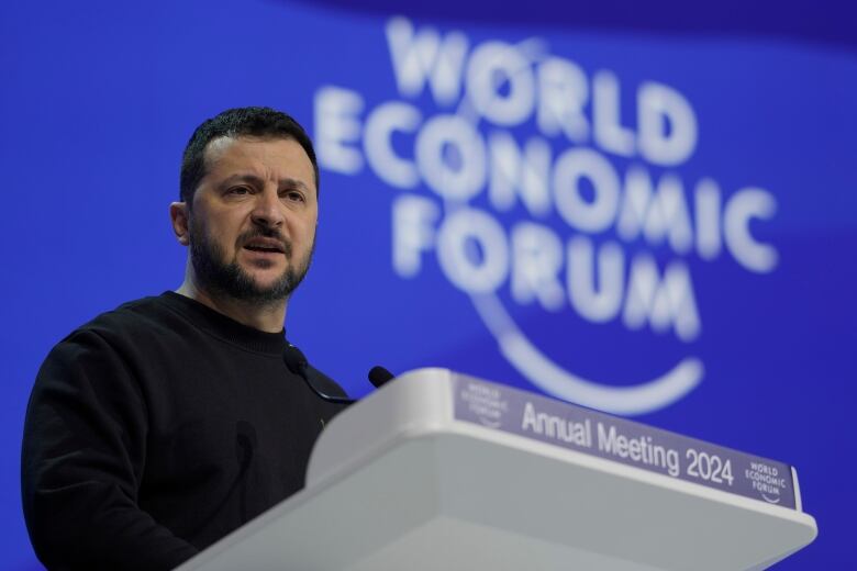 Ukrainian President Volodomyr Zelenskyy speaks at a podium with the World Economic Forum logo in the background