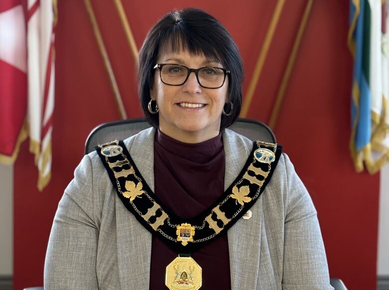 A smiling woman wearing a Mayor's livery collar.