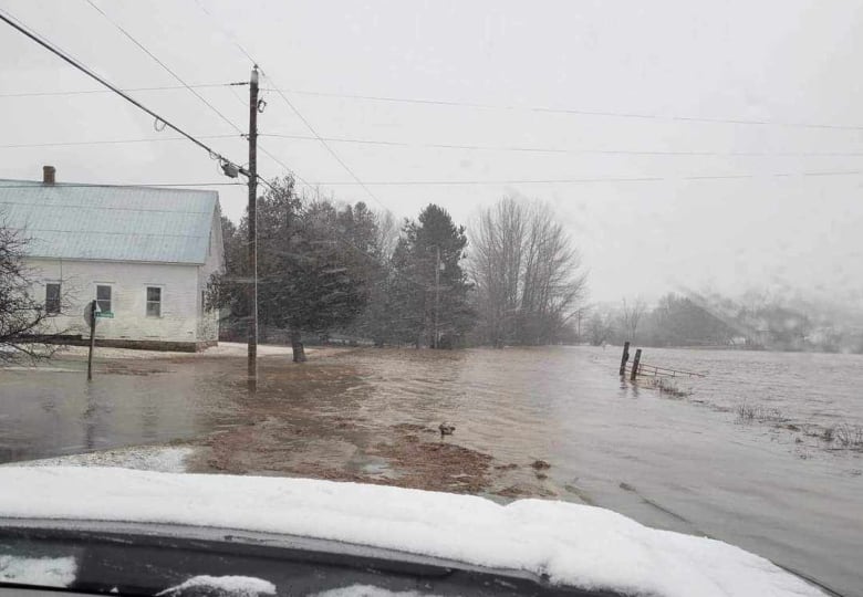 A view from inside a vehicle of a flooded road.