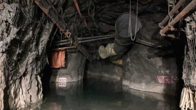 Water is seen in the underground workings of a mine.