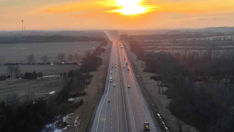 A four-lane highway at sunset in late winter. It's more empty than full.