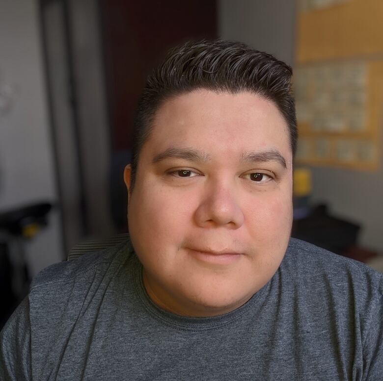 An Indigenous man in a gray shirt. 