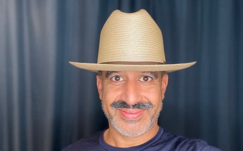 A man with a moustache wears a Stetson hat