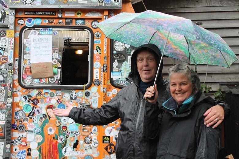 A man stands with a woman holding an umbrella while on vacation in B.C.