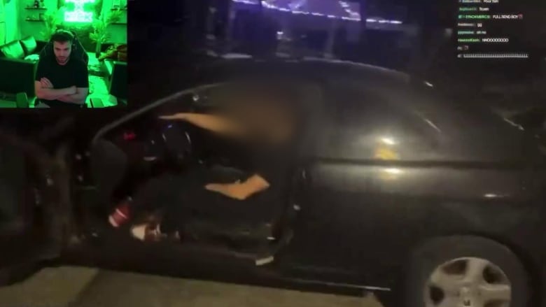 A screengrab of a livestream video shows a man sitting in his black car.