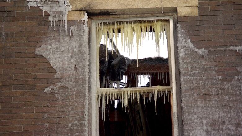 A broken window covered with icicles. 