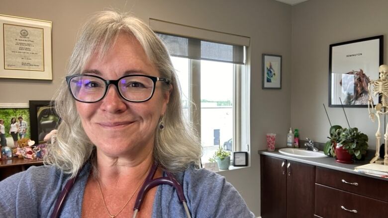 Dr. Debi O'Leary stands inside the office of her family medicine practice.