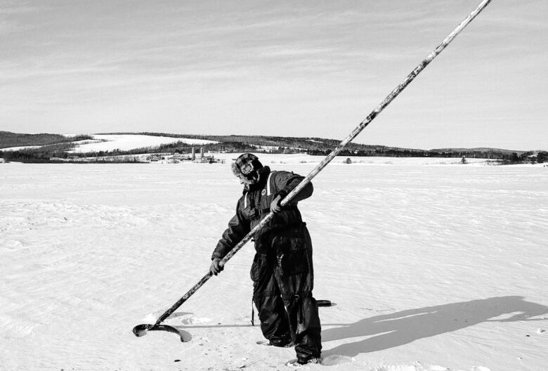 Man standing with an eel in his spear