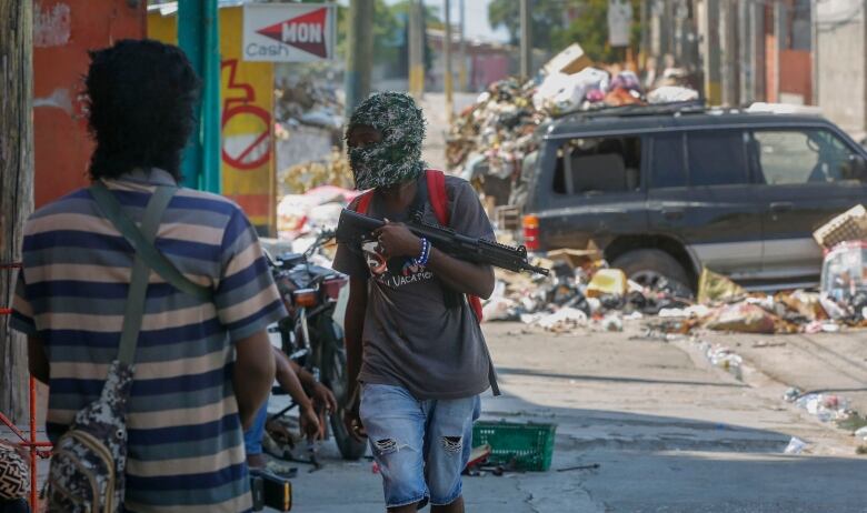 Masked gunmen patrol the streets in Haiti. 