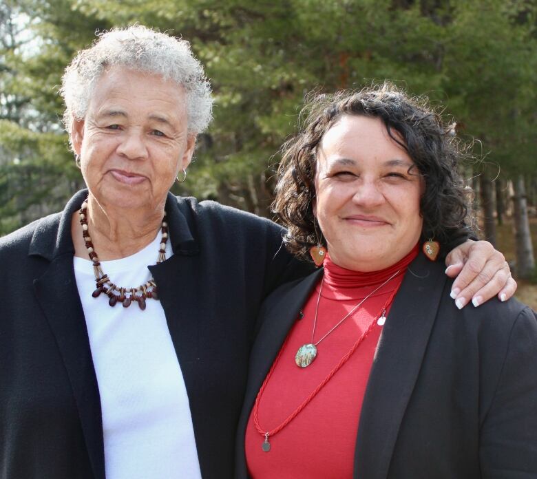 Two women smile for a photo next to each other.