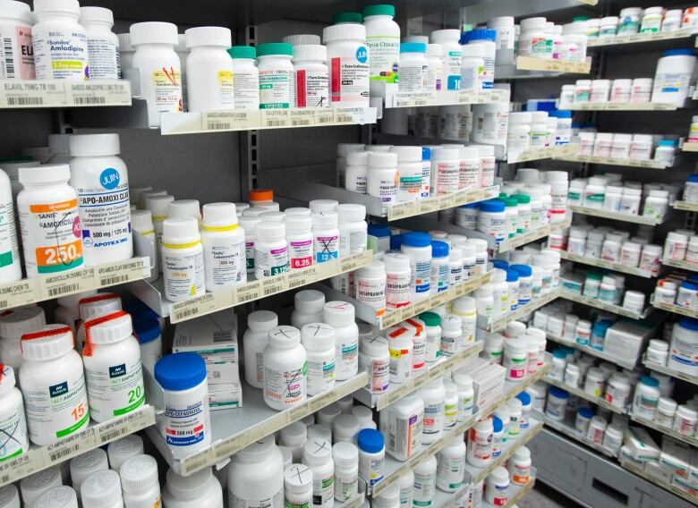 Shelves filled with prescription drugs are shown at a pharmacy.