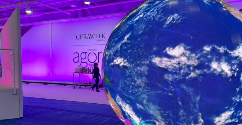 A digital globe spins in the hallway at a conference centre.