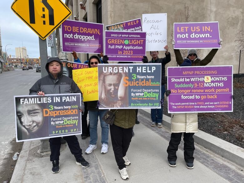 People hold up signs in protest.