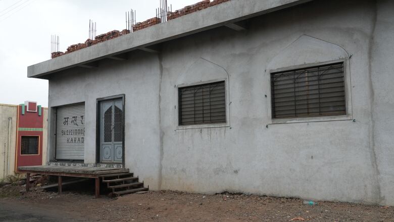 A mosque with an off-white exterior and pale blue door.