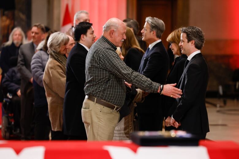 People greet members of the Mulroney family as former prime minister Brian Mulroney lies in state in the Sir John A. Macdonald building opposite Parliament Hill in Ottawa, on Tuesday, March 19, 2024. 