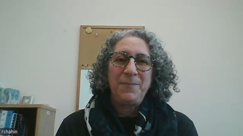 Screenshot from a Zoom call of a woman with glasses and curly grey hair. 