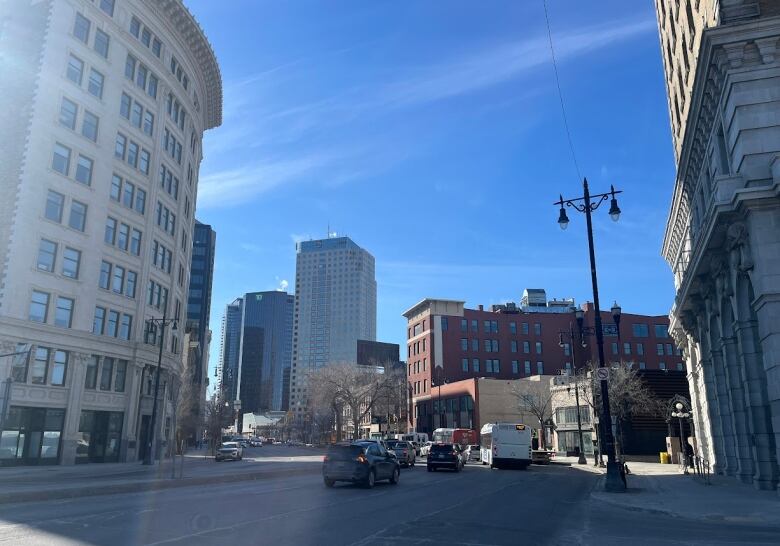 Street scene of a downtown with buildings and traffic.