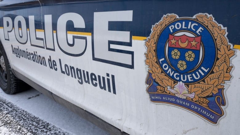 A white and blue car is seen with the Longueuil police logo on the side.