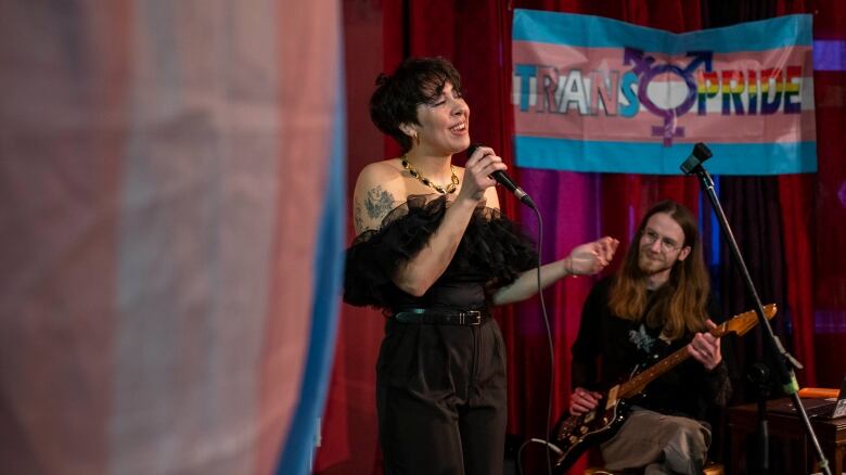 Performers sing on a stage.