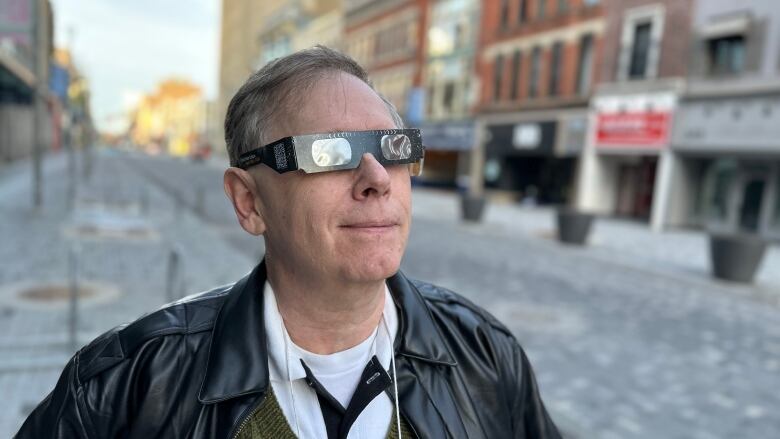 Local eclipse expert Peter Jedicke, from London's chapter of the Royal Astronomical Society of Canada, tests out his solar viewers on Dundas Street. 