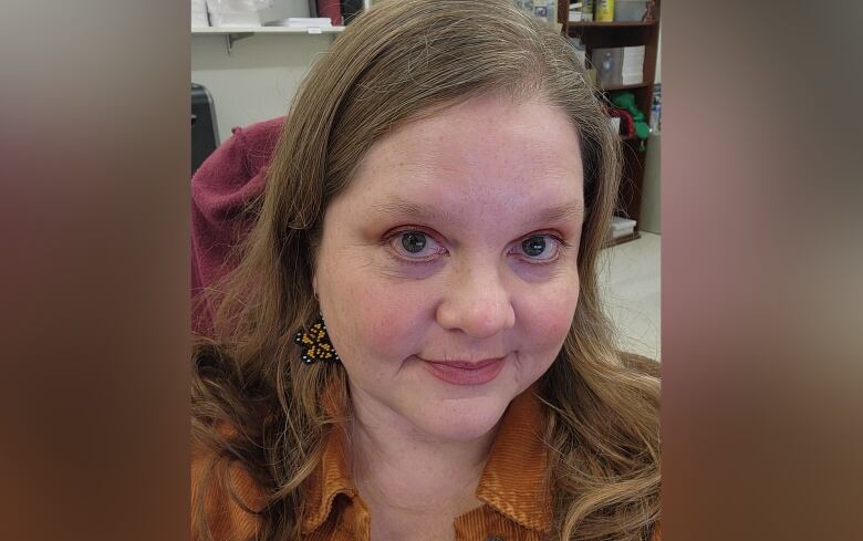 A woman with long blond hair stares into the camera.