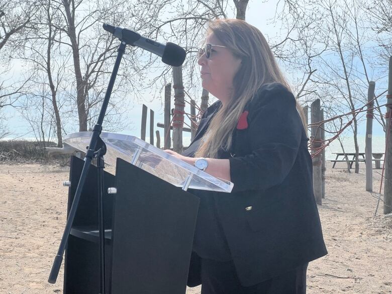 A woman stands at a podium