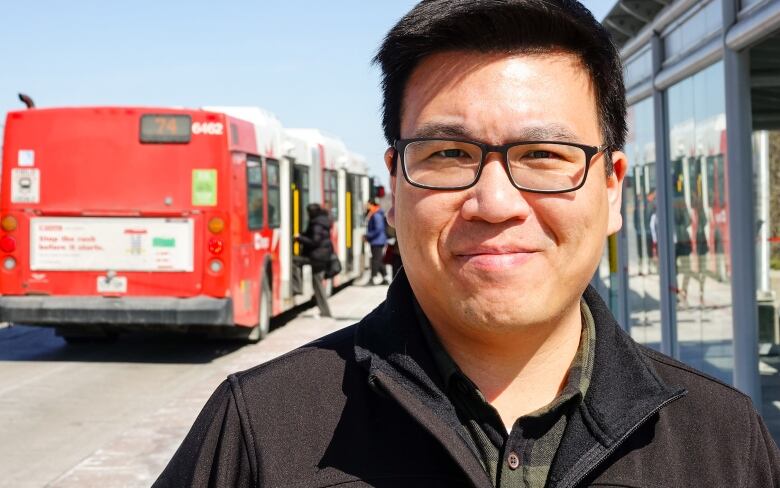 A politician poses at a bus stop in early spring.