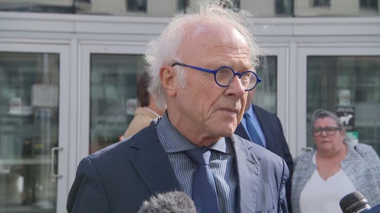 Lawyer stands outside courthouse.