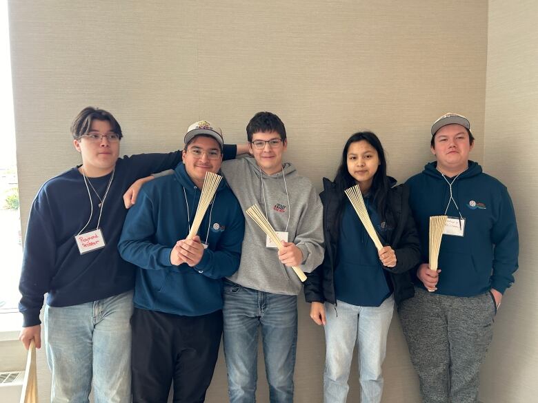 5 youth holding fan-like instruments.