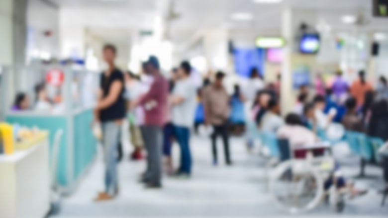 A blurred image of patients in a hospital waiting room.