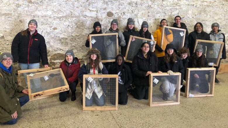 Group of youth holding turtles nest protectors. 