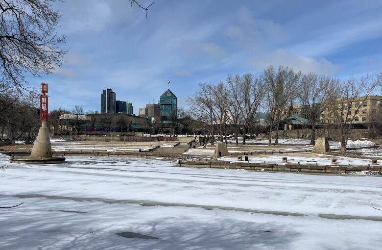 A boat docking harbor is seen across an ice-covered river.